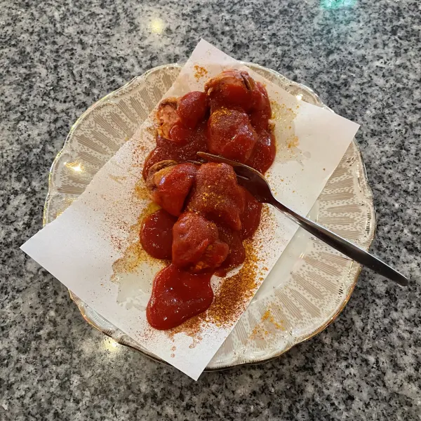 Currywurst ohne Darm auf Porzellanteller bei Bier's am Ku'damm